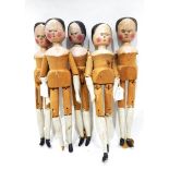 Five 19th century pine dolls, each with articulated joints and naively painted heads, arms and legs,