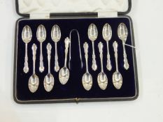 Set of 12 silver tea/coffee spoons with tongs ensuite, of scroll outline ,