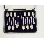 Set of 12 silver tea/coffee spoons with tongs ensuite, of scroll outline ,