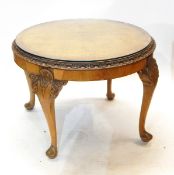 Circular walnut occasional table with glazed top, the edges decorated with floral carving,