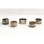 Five assorted silver napkin rings, one with engine-turned decoration and engraved 'Pam',