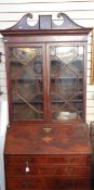 Georgian flame mahogany bureau bookcase, the top with swan neck pediment, urn and swag inlay,