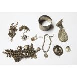 Silver curb link charm bracelet hung with multiple silver charms including a compass, a flask, etc.