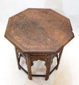 Octagonal Eastern folding occasional table with brass scroll and floral inlay,