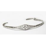 White gold and diamond bracelet set with a central brilliant cut diamond within a pierced surround