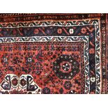 Persian style wool rug with pink ground and floral and geometric decoration, black borders,