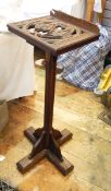 Stained oak adjustable reading/music stand, carved lion and shield, on octagonal column,