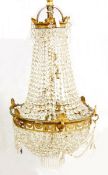 20th century brass electrolier, three-tier with graduated cut glass droplets,