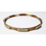 9ct gold bangle of alternating engine-turned panels and bar design, 19g approx.