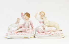 Pair of continental porcelain figure groups of young boy and girl with dog on octagonal bases,