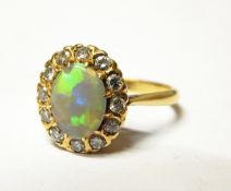 Gold, opal and diamond cluster ring, the central oval opal surrounded by 12 eight-cut diamonds,