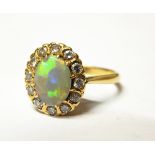 Gold, opal and diamond cluster ring, the central oval opal surrounded by 12 eight-cut diamonds,