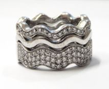 Matched set of three 18ct white gold and diamond wave-pattern rings,