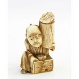 Japanese carved ivory netsuke, man seated and holding a cylinder,