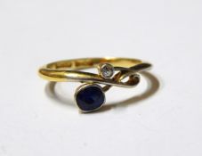 Sapphire and diamond crossover ring, the oval mixed cut sapphire set opposite an eight cut diamond,