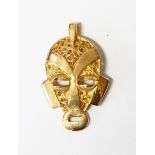 Gold pendant modelled as a mask with filigree decoration,