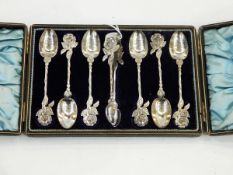 Set of six silver teaspoons with sugar tongs having rose finials,