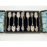 Set of six silver teaspoons with sugar tongs having rose finials,