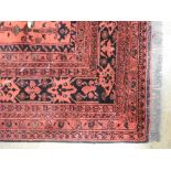 A Persian style carpet with six central medallions on red field within multi border, 200cm x 155cm .