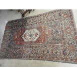 A hand made Persian Malayer rug, the central medallion within a wide border on red and blue field,
