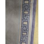 A contemporary runner, the blue and indigo Greek key style border around a grey field.