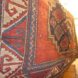 A hand knotted Kazak rug the red ground