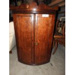 A George III style oak and mahogany inlaid corner cabinet with twin panel doors