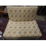 A floral upholstered two seater futon. 120cm (w) 8cm (d) 82cm (h)