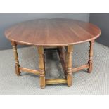 A 20th Century cherrywood wake/hunting table, the drop flap top above turned stretchered supports