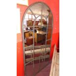 A large garden style mirror the arched plate within wrought iron divisional frame