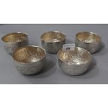 A set of five Thai white metal bowls with embossed detail, possibly silver