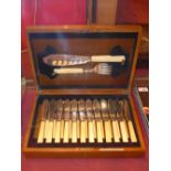 A cased set of twelve silver plated fish knives and forks in a mahogany case