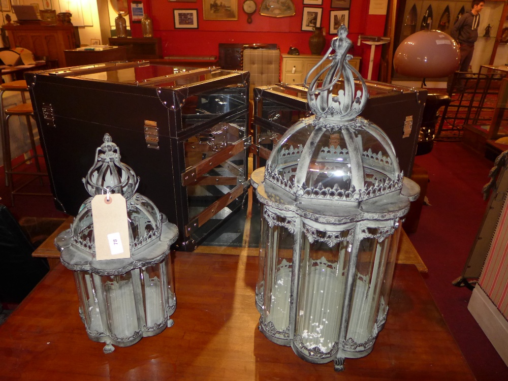 A pair of pagoda form wrought iron and glazed hanging storm lanterns of graduating size