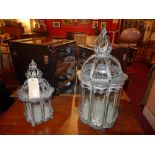 A pair of pagoda form wrought iron and glazed hanging storm lanterns of graduating size