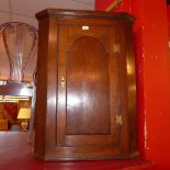 A Georgian oak corner cupboard fitted single panel door enclosing shelves