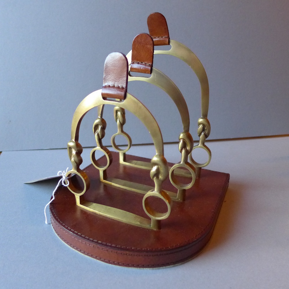 A tan leather and brass letter rack of three divisions.