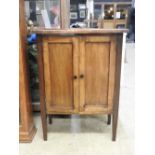 An early 20th Century mahogany side cabinet, the twin cupboard doors over slender tapered supports