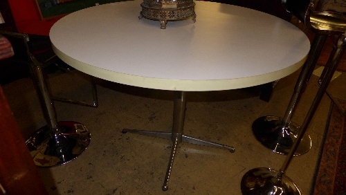 A contemporary retro breakfast table, the circular white melamine top on chromium base 78cm x 110cm