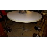 A contemporary retro breakfast table, the circular white melamine top on chromium base 78cm x 110cm