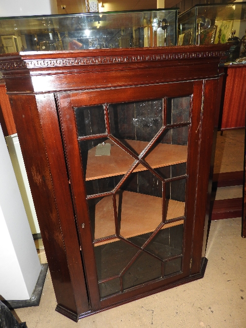 A Victorian style wall hanging mahogany corner cabinet with glazed panel doors