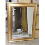 A contemporary wall hanging mirror in gilt frame. 90cm x 65cm