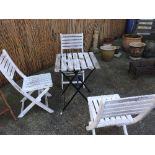 A 20th century distressed painted garden table and four folding chairs (5)