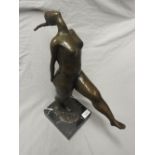 A bronze sculpture of a confident female on a square marble base.