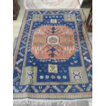 A hand woven Turkish carpet, indigo ground with large central gul enclosed by stepped vine leaf