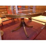 A mahogany dining table the circular top