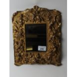 A gilt metal cherub mirror with easel support