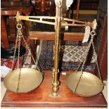 A set of antique oversized scales, brass mounted on mahogany stand,