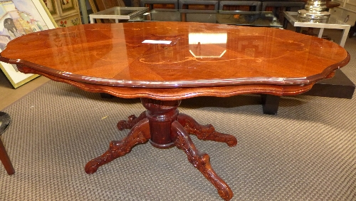 A 20th century Italian walnut and inlaid low table of ovoid outline on a carved quatreform base L