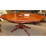 A 20th century Italian walnut and inlaid low table of ovoid outline on a carved quatreform base L