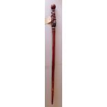 An intricately carved Tanzanian solid rosewood walking stick, H.100cm.